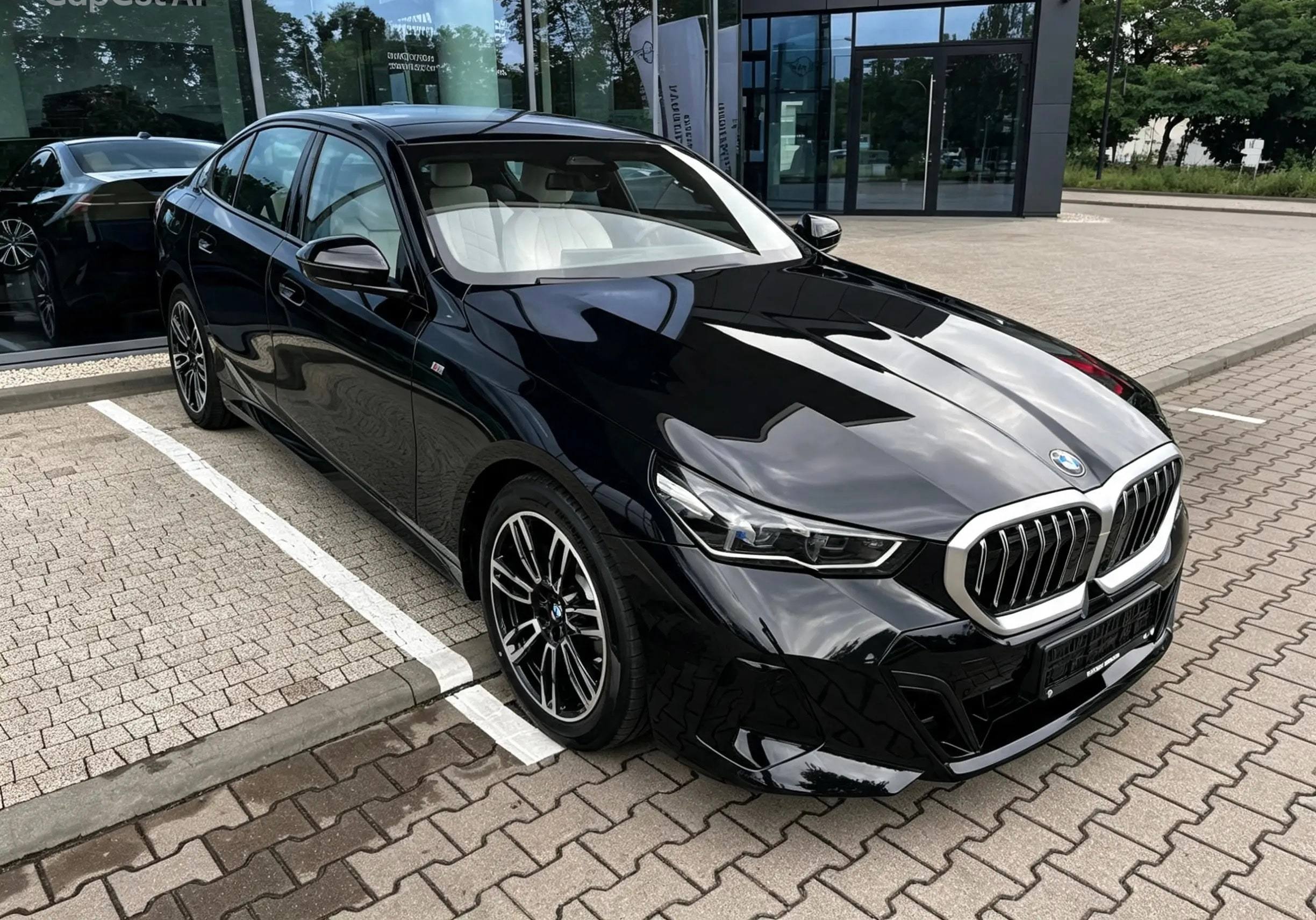 Czarne BMW serii 5 zaparkowane przed przeszklonym salonem